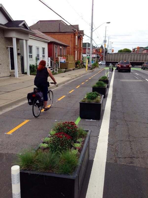 Cyclist riding past the Canon Cycle Track planter boxes (Image Credit: Jason Leach)