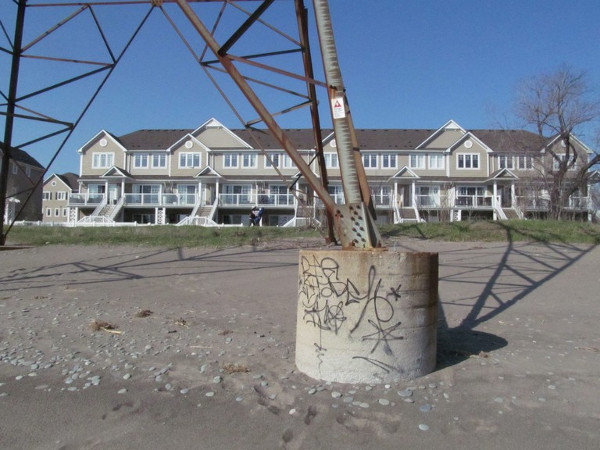 Nondescript graffiti on the base of the hydro towers stand in front of new condos popping up on the Hamilton Beach Strip.