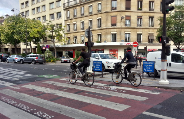 Couple riding Vélib' bikes in transit lane
