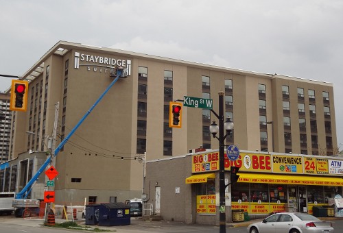 A crane attaches the sign to the side of Staybridge Suites hotel (RTH file photo)