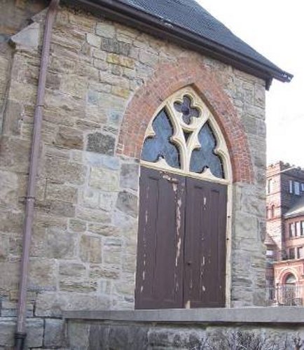 Figure 4: The doorway at the northwest corner, which was constructed after the tower was removed in 1998. Brick was used in place of stone voussoirs, and the repaired masonry shows inferior workmanship.