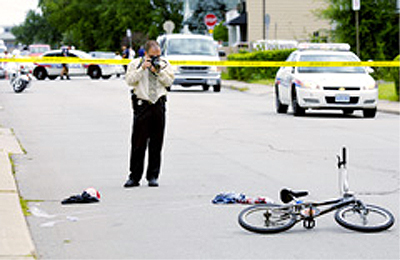 A police officer investigates the fatal cycling collision on Glow Avenue (Photo Credit: Barry Gray, Hamilton Spectator)
