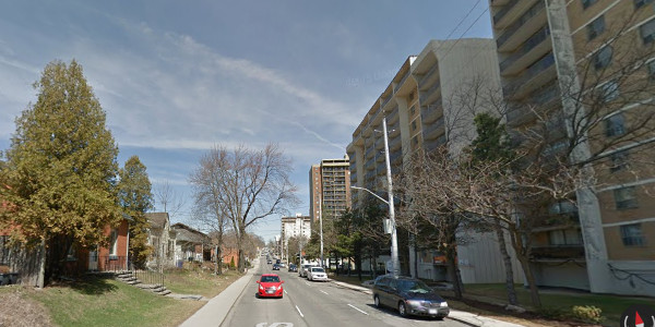 Tall buildings across from houses on Queen Street South