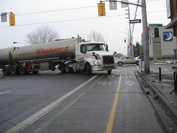 Transport truck cutting into Cannon Cycle Track while turning from Wellington onto Cannon (Image Credit: Lynda Lukasik)