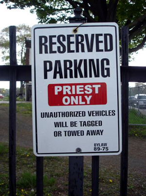 Sign: RESERVED PARKING PRIEST ONLY UNAUTHORIZED VEHICLES WILL BE TAGGED OR TOWED AWAY