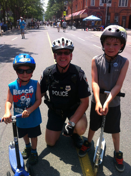 Police officer with two young scooterers