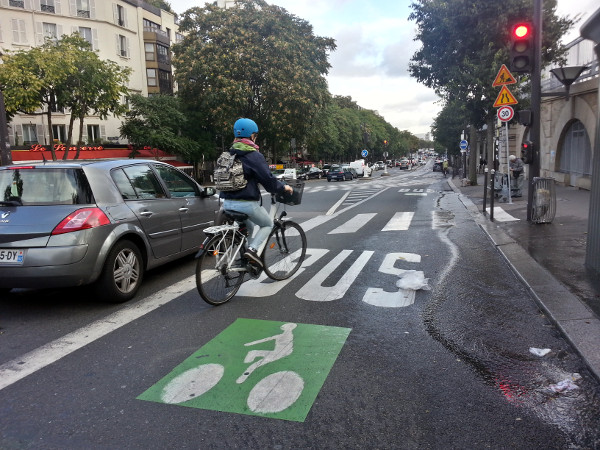 Cyclist riding in transit lane, bundled up on a cold day