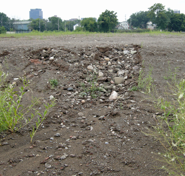 Looking south. The January material was supplemented and eventually the whole burden was spread to a depth of about a metre over the northern half of the block. By summer the rain had begun to cut channels revealing the large quantity of beach stone in the fill.