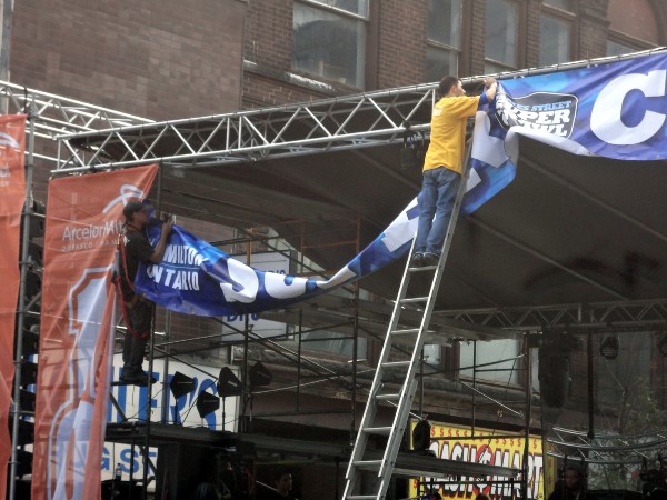 Stage crew hang the SUPERCRAWL banner
