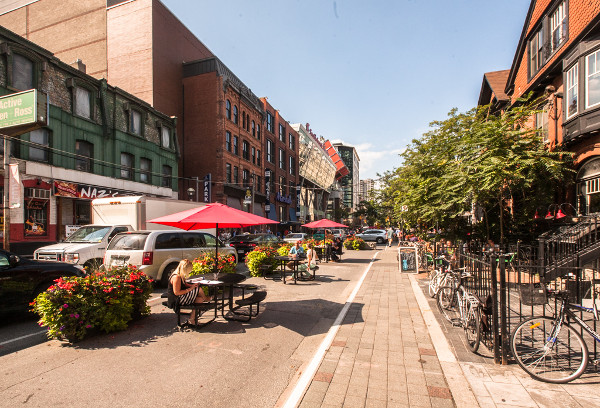 John Street, Toronto with a lane blocked by planters for tables and chairs (Image Credit: Torontoist)