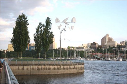 A kinetic wind sculpture on the seawall at George Wainburn Park.  The lower density 1970s development on the South Shore of False Creek can be seen in the background.