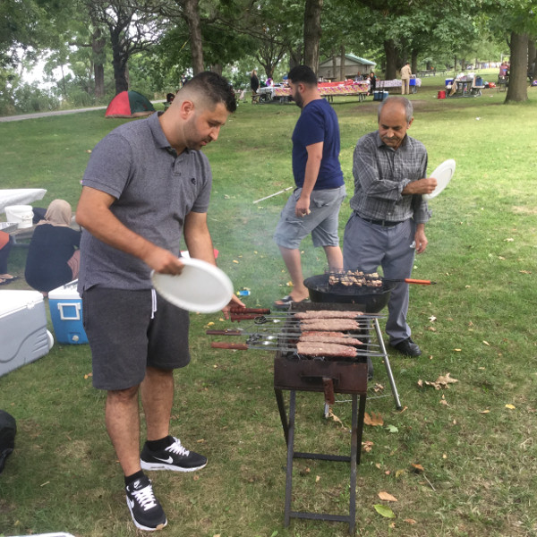 This family was originally from Tajikistan and made their way to Canada via Greece and then Quebec, and now reside on Hamilton Mountain. The gentleman is barbecuing kebabs. The women were nearby on the ground preparing the meat.