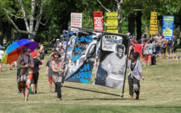 Pride 2018 attendees counter religious bigots (in background). The same bigots returned the next year, and again the police stood by.