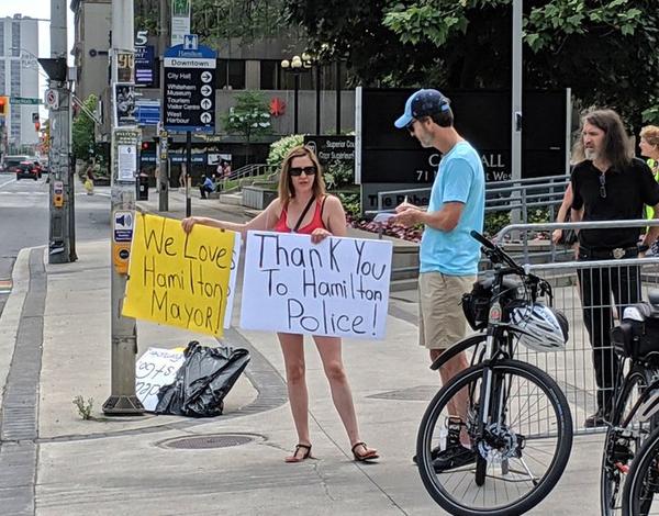 Right-wing demonstrator holding signs of support for the Mayor and Police